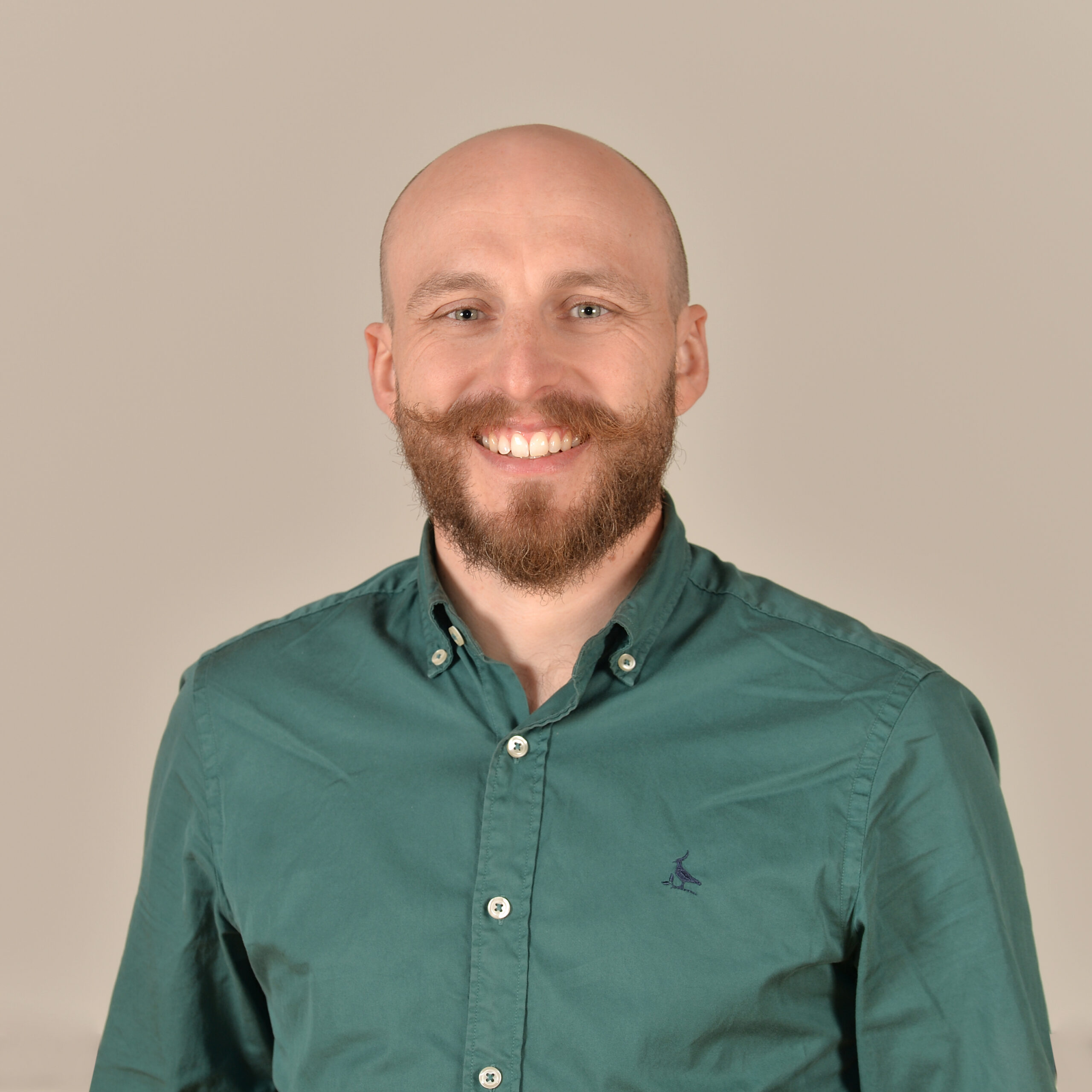 Profilbild von Dr. Tobias Brändle in einem grün-blauen Hemd.