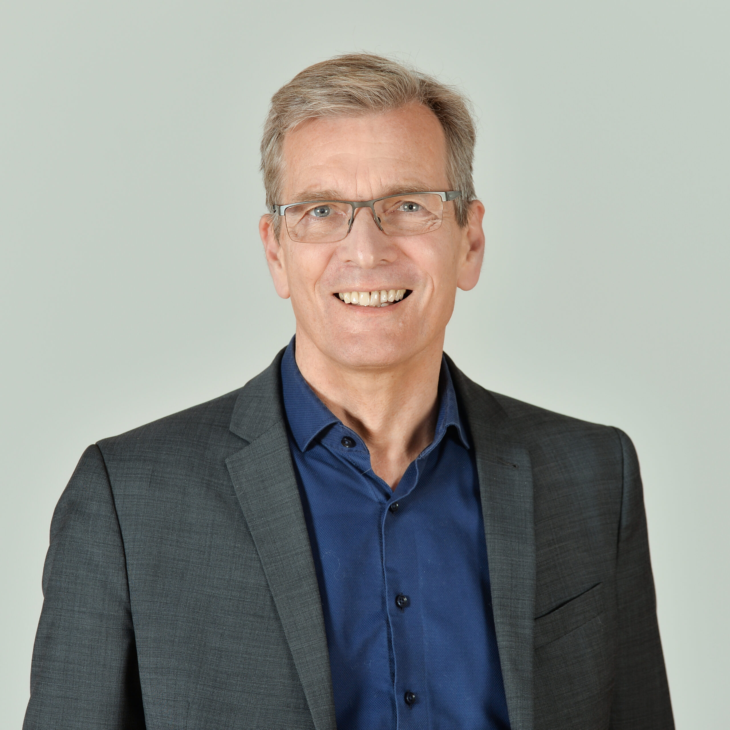 Profilbild von Thomas Bernt. Er trägt ein dunkel-blaues Hemd und ein graues Jackett.